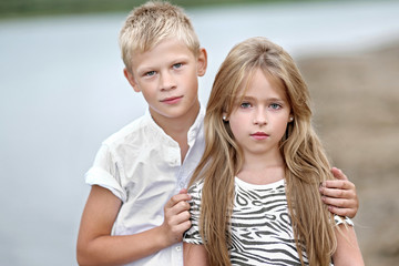 Portrait of a boy and girl on the beach in summer