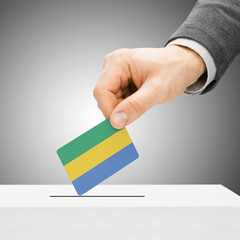 Voting concept - Male inserting flag into ballot box - Gabon