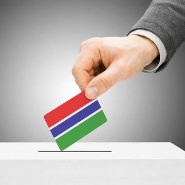 Voting concept - Male inserting flag into ballot box - Gambia