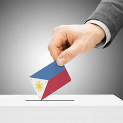 Voting concept - Male inserting flag into ballot box - Philippin