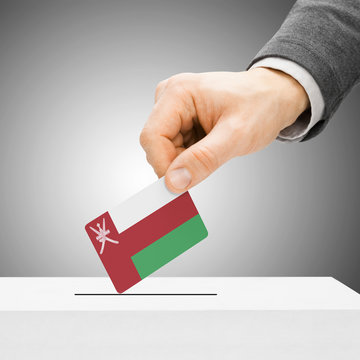 Voting concept - Male inserting flag into ballot box - Oman