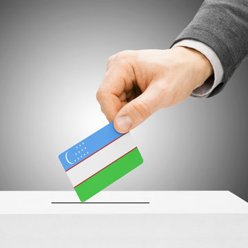 Voting concept - Male inserting flag into ballot box - Uzbekista