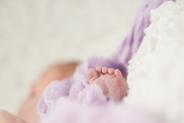 Two weeks newborn's feet under  blanket