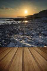 Fototapeta na wymiar Long exposure landscape rocky shoreline at sunset with wooden pl