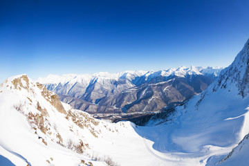 Obraz premium Panorama of snowy mountains from the peak in Sochi