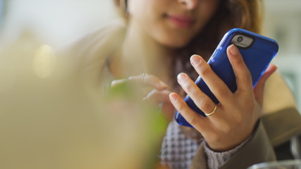 Female hands using a phone indoors