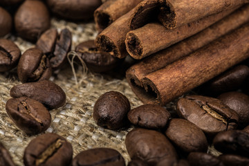 coffee beans with cinnamon sticks on sack textile