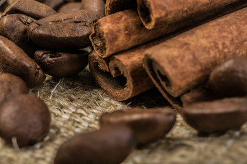 coffee beans with cinnamon sticks on sack textile