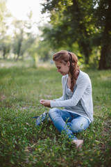 Fototapeta premium Young girl sitting on the grass