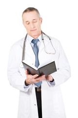 Mature male doctor reading notes