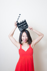 Young beautiful asian woman red dress smiling with clapperboard