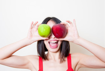 Funny young woman with red and green apples over eyes