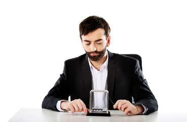Man moving newton balls in office.