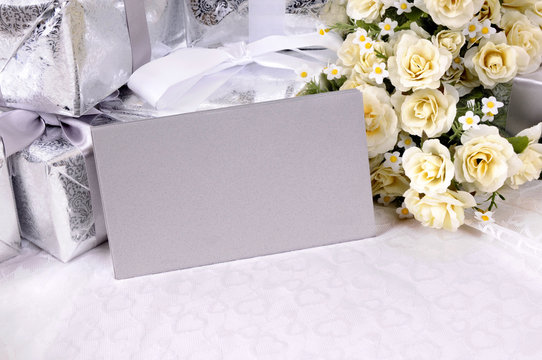 Wedding gifts with invitation envelopes flowers and white lace background photo