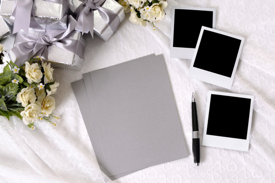 Wedding gifts white lace background with writing paper and polaroid style picture frame photos