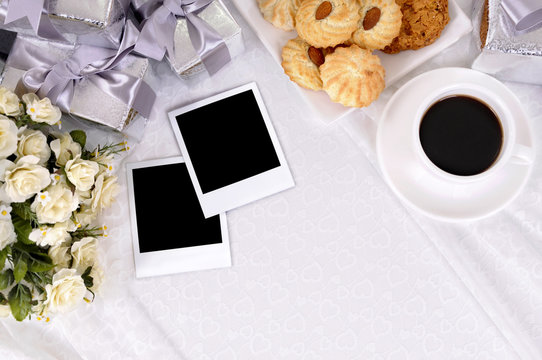 Wedding gifts and polaroid style photo print frames with coffee and biscuits background