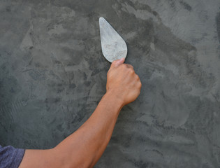 plasterer concrete worker at wall of house construction
