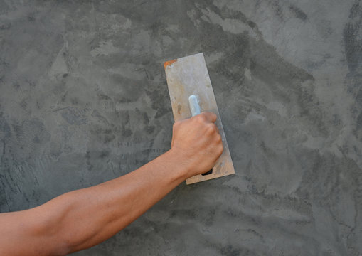 plasterer concrete worker at wall of house construction
