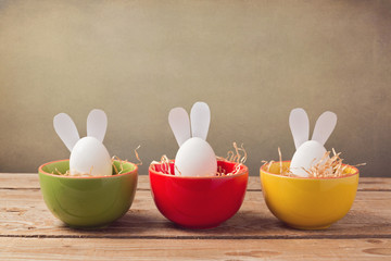 Easter holiday eggs with bunny ears on wooden table