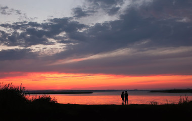 Fototapeta na wymiar Couple at Beach on Sunset Background