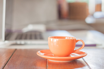 Mini orange coffee cup on work station