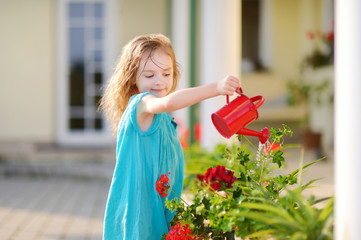 Cute little girl watering flowers © MNStudio
