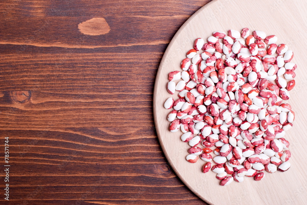 Wall mural raw speckled beans on board diet food