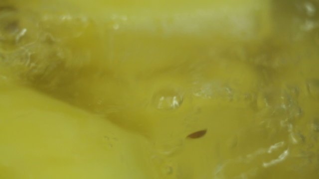 Macro of potatoes boiling in water with cumin.