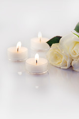 Fototapeta na wymiar weiße Rosen mit Teelichtern