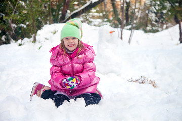 Fototapeta na wymiar Cute blonde girl making snowball