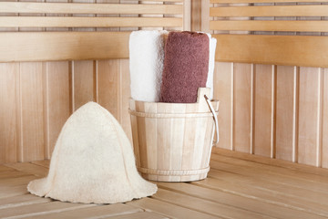 Traditional wooden sauna for relaxation with bucket of water and