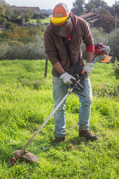Man cutting grass in back yard
