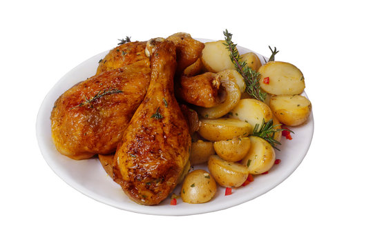 Fried chicken legs with potatoes, rosemary and thyme spices