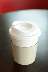 Take away coffee cup on the table- soft focus