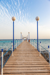 Obraz premium wooden pier leading to open blue sea