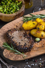 Beef steak with roasted potatoes and herbs, top view