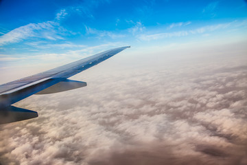 Fototapeta na wymiar Wing of the plane on blue sky background