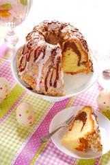 ring cake with icing and chocolate glaze on easter table