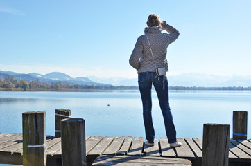 Girl on the wooden jetty at a lake. Switzerland