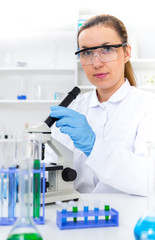 Woman working with a microscope in a lab