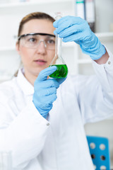 Chemist woman testing sample of liquid in laboratory