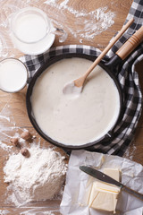 bechamel sauce in pan and ingredients vertical top view