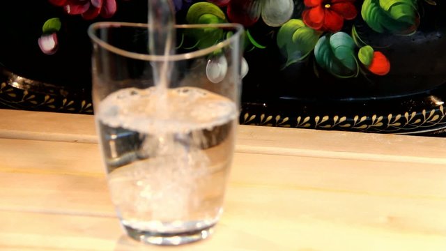 Process of pouring water into a glass beaker