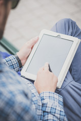 close up hands man using tablet on the bench