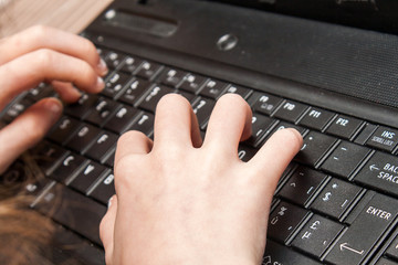 children's hands typing on a laptop keyboard - 78591958