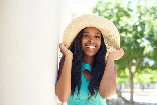 Happy Young Woman Laughing And Holding Sun Hat