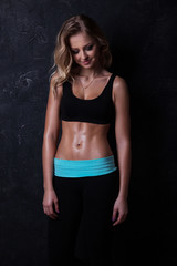Fototapeta na wymiar Sport blond woman with wavy hair showing her well trained body a