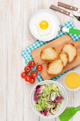 Healthy breakfast with fried egg, toasts and salad