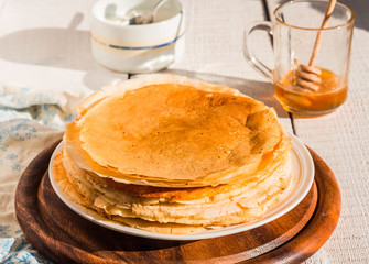 thin pancakes with honey and sour cream, rustic