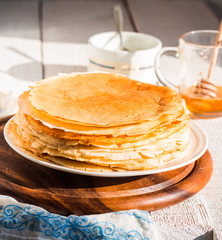 thin pancakes with honey and sour cream, rustic